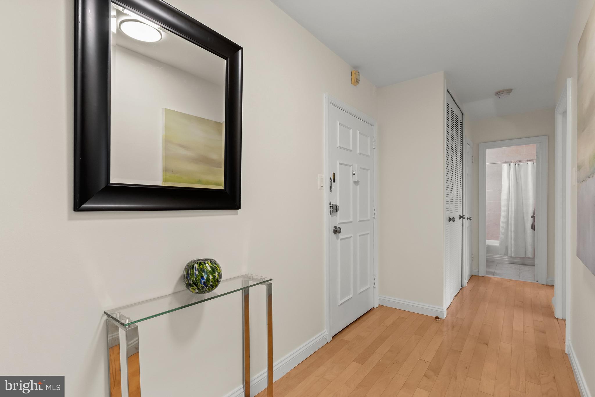 4000 Tunlaw Road Northwest, Unit 1007 Washington, DC 20007 - Photo 16 of 50 a view of a hallway with wooden floor and a mirror