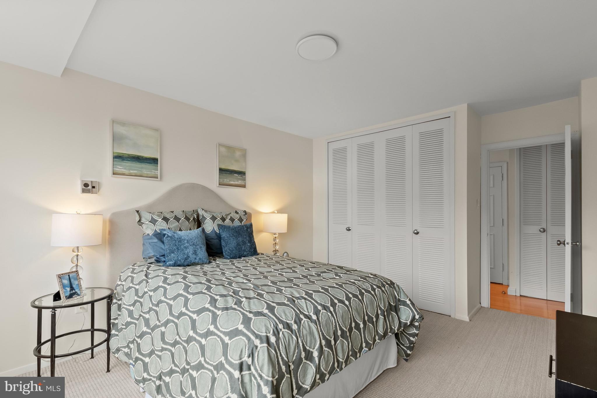 4000 Tunlaw Road Northwest, Unit 1007 Washington, DC 20007 - Photo 25 of 50 a bedroom with a bed and a lamp