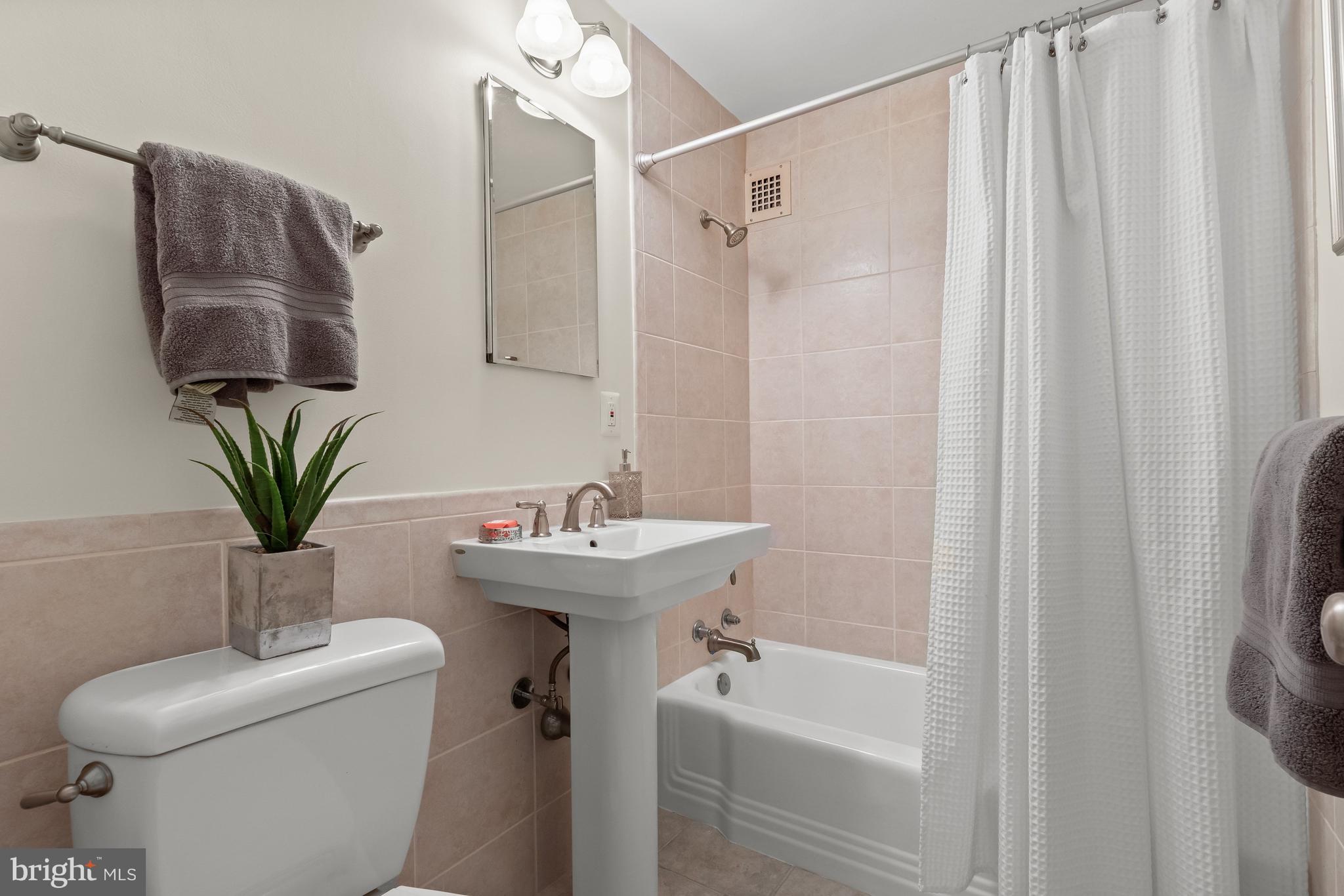4000 Tunlaw Road Northwest, Unit 1007 Washington, DC 20007 - Photo 26 of 50 a bathroom with a sink toilet and shower