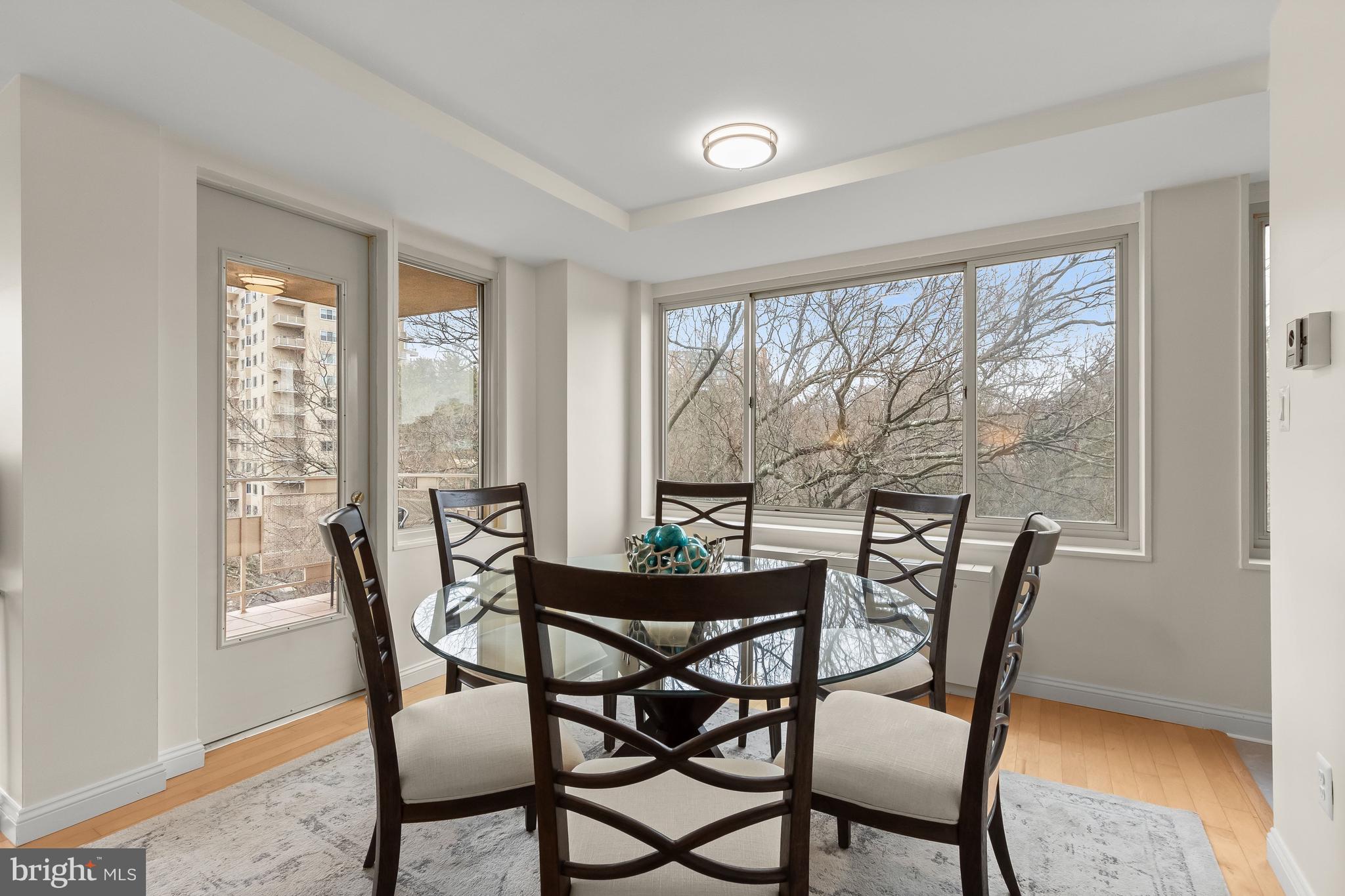 4000 Tunlaw Road Northwest, Unit 1007 Washington, DC 20007 - Photo 8 of 50 a view of a dining room with furniture large windows and wooden floor