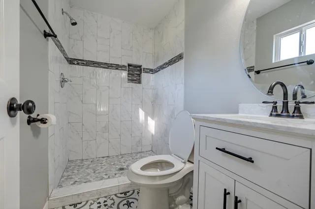 a bathroom with a sink a toilet and shower