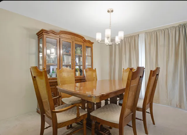 a view of a dining room with furniture and chandelier