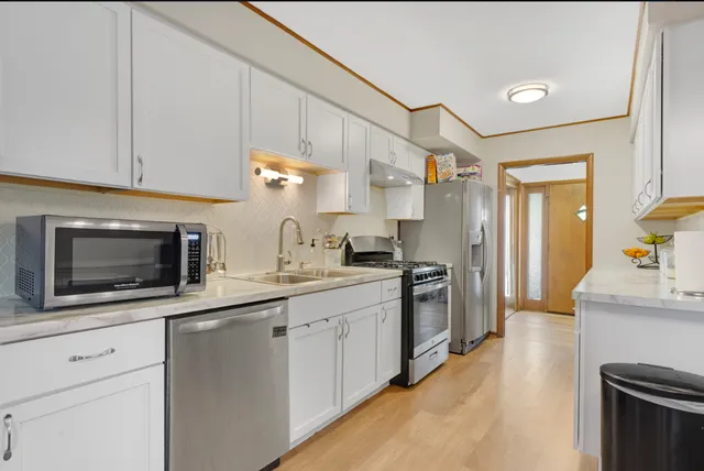 a kitchen with stainless steel appliances a stove microwave and a sink