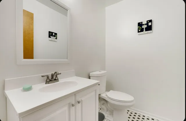 a bathroom with a sink mirror and toilet