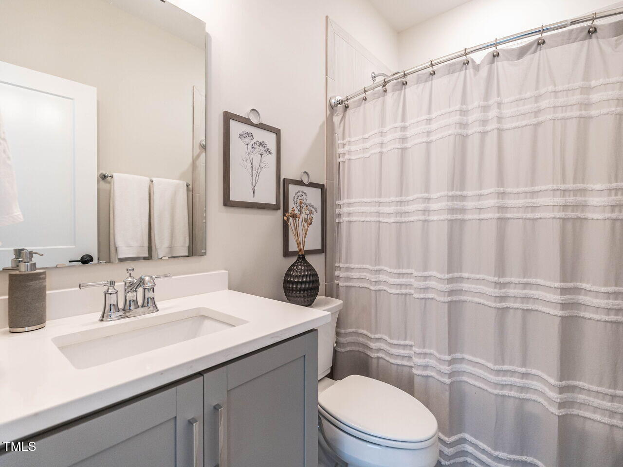 1610 Draper View Loop, Unit 101 Raleigh, NC 27608 - Photo 28 of 39 a bathroom with a sink a toilet and shower curtain