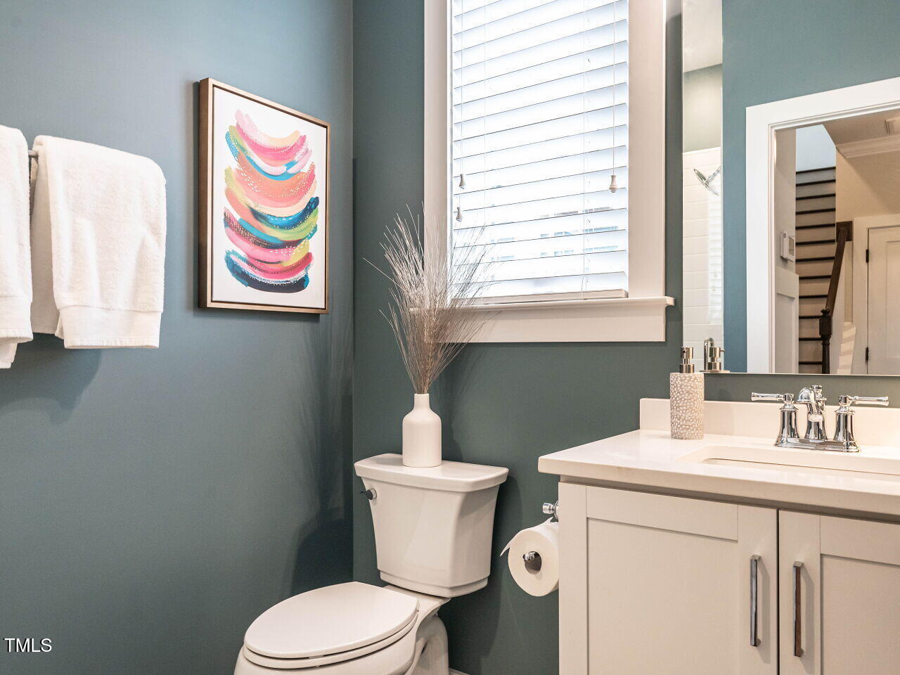 1610 Draper View Loop, Unit 101 Raleigh, NC 27608 - Photo 4 of 39 a bathroom with a sink a toilet and a mirror