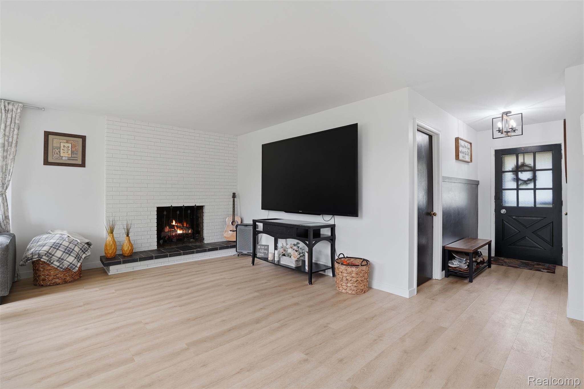 47129 Dunsany Road Northville, MI 48167 - Photo 6 of 49 Living room with light wood-style floors, a fireplace, and hanging lights