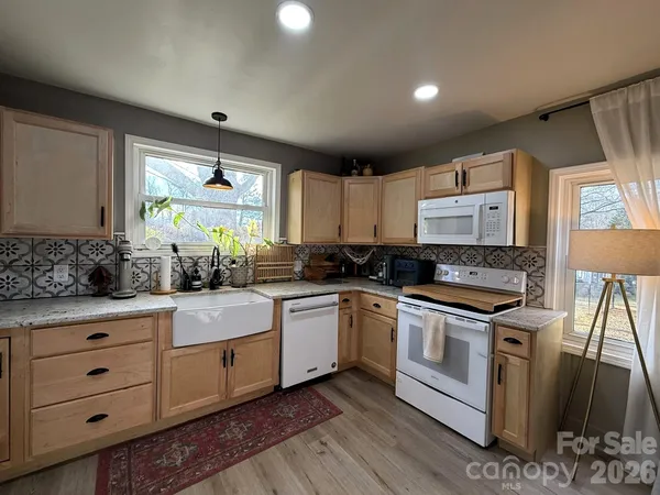 a kitchen with granite countertop white cabinets and white appliances