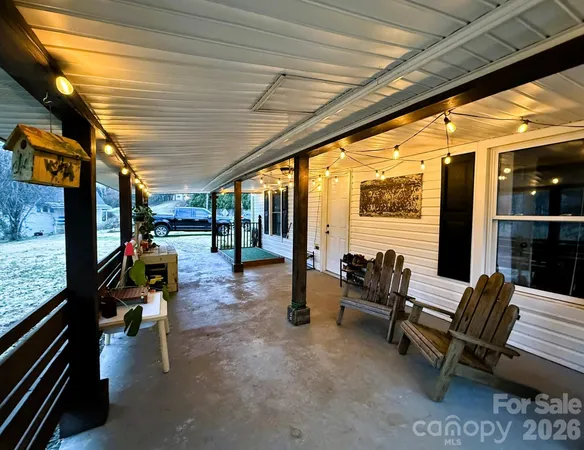 an outdoor living room with furniture and a floor to ceiling window