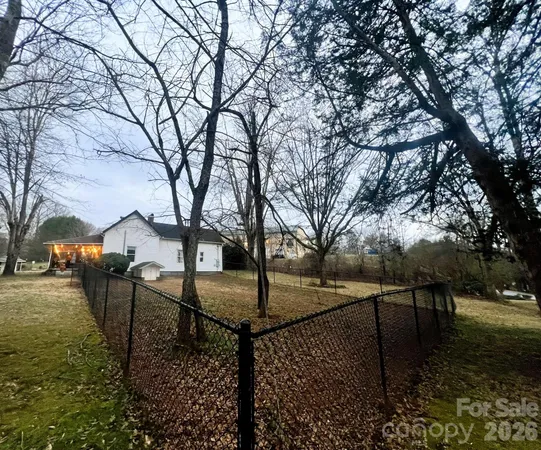 a view of a yard with wooden fence