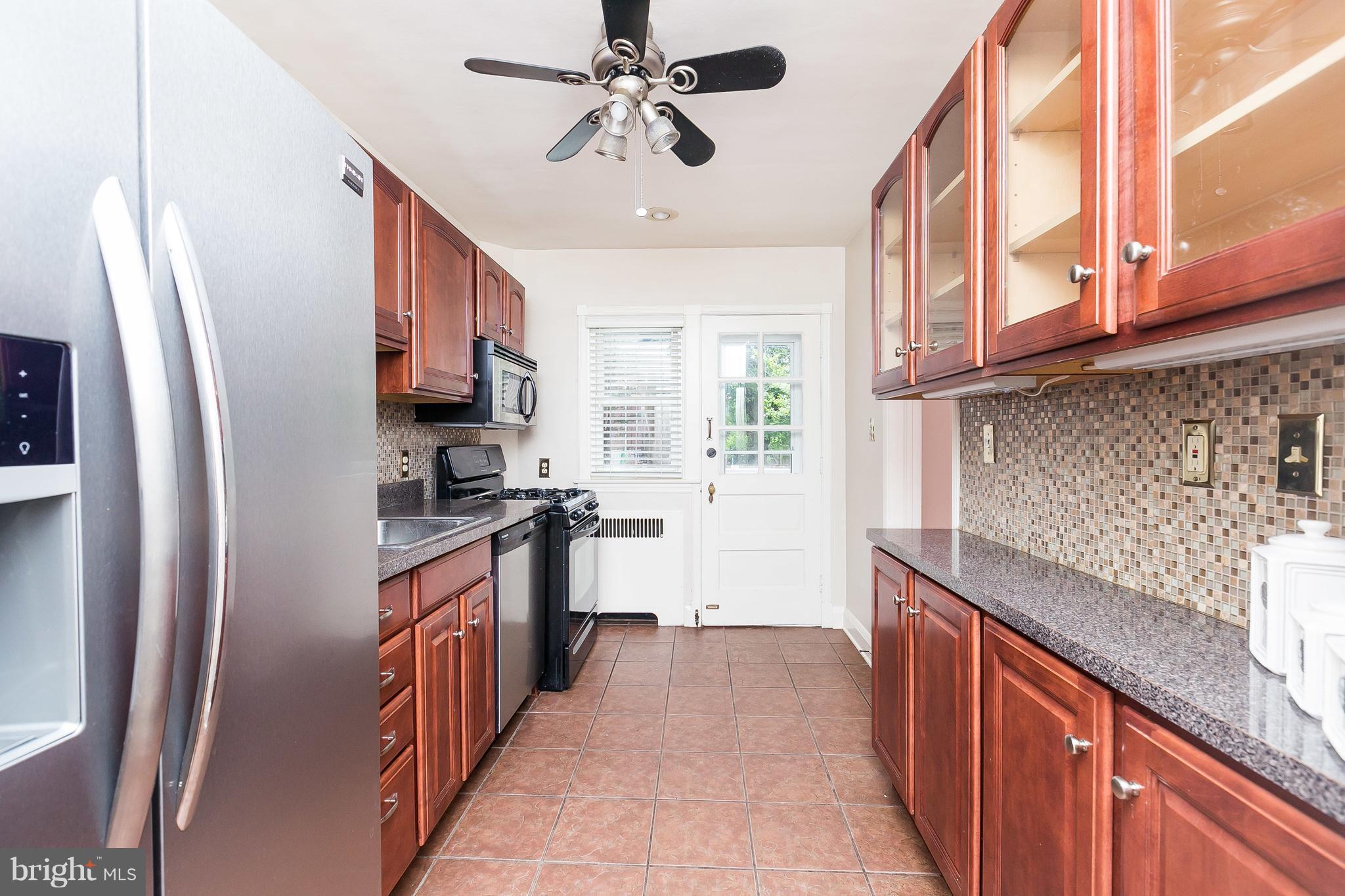 39 Murdock Road Baltimore, MD 21212 - Photo 12 of 28 a kitchen with stainless steel appliances granite countertop a refrigerator a sink dishwasher a stove and white countertops with wooden floor