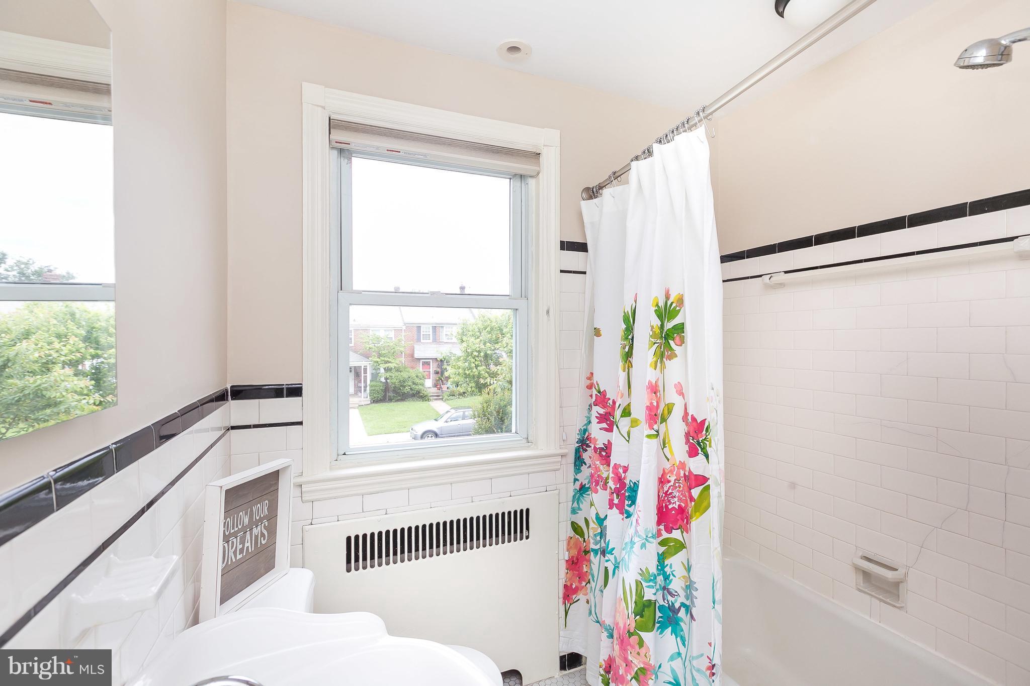 39 Murdock Road Baltimore, MD 21212 - Photo 22 of 28 a bathroom with a sink a bathtub and window