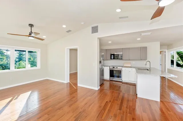 a open kitchen with white cabinets and white appliances
