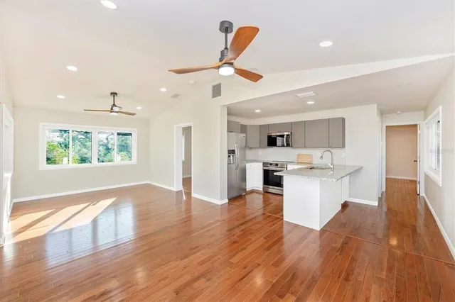 a view of kitchen with wooden floor electronic appliances and window