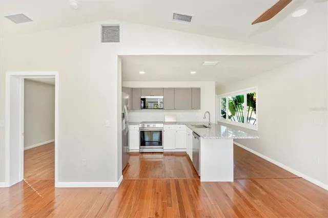 a large kitchen with a center island and stainless steel appliances