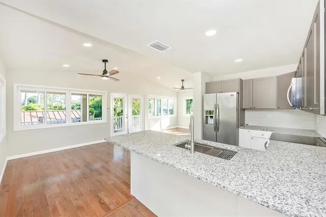 a kitchen with stainless steel appliances granite countertop a refrigerator and a sink