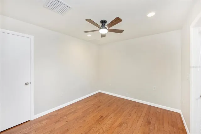 a view of empty room with wooden floor