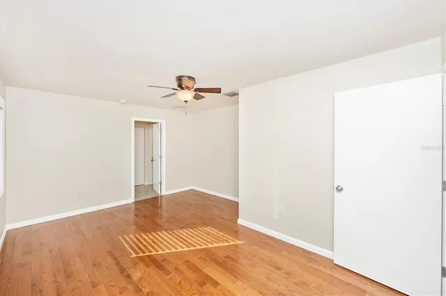 a view of empty room with wooden floor