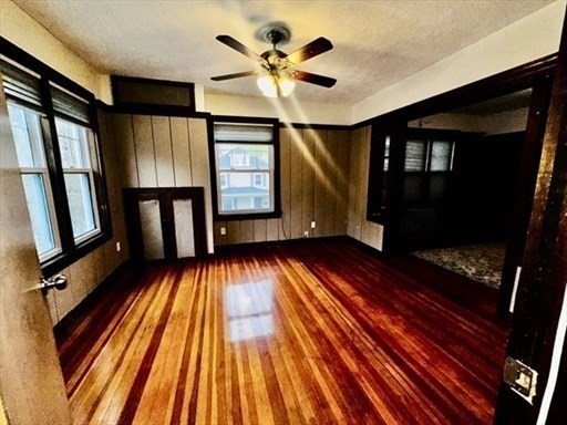 59 14th Avenue, Unit 2 Haverhill, MA 01830 - Photo 3 of 11 a view of an empty room with wooden floor and a window