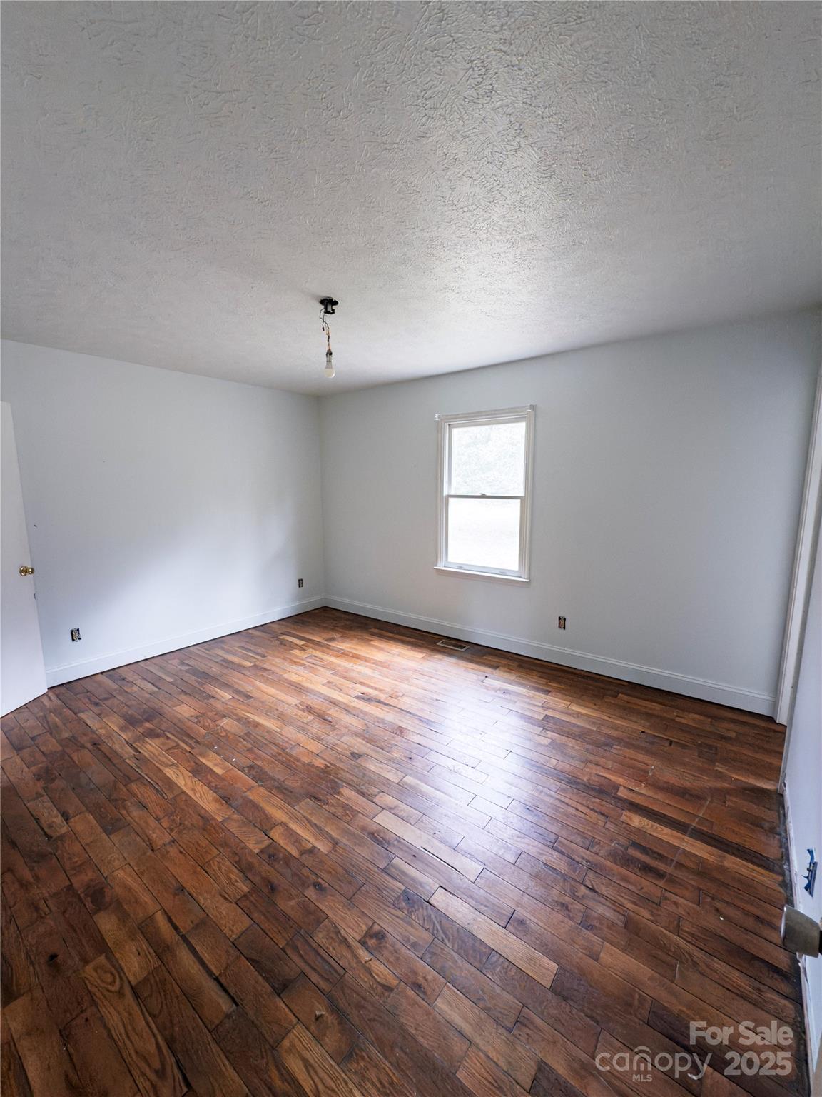 931 Emerald Place Southwest Lenoir, NC 28645 - Photo 5 of 10 an empty room with wooden floor and windows
