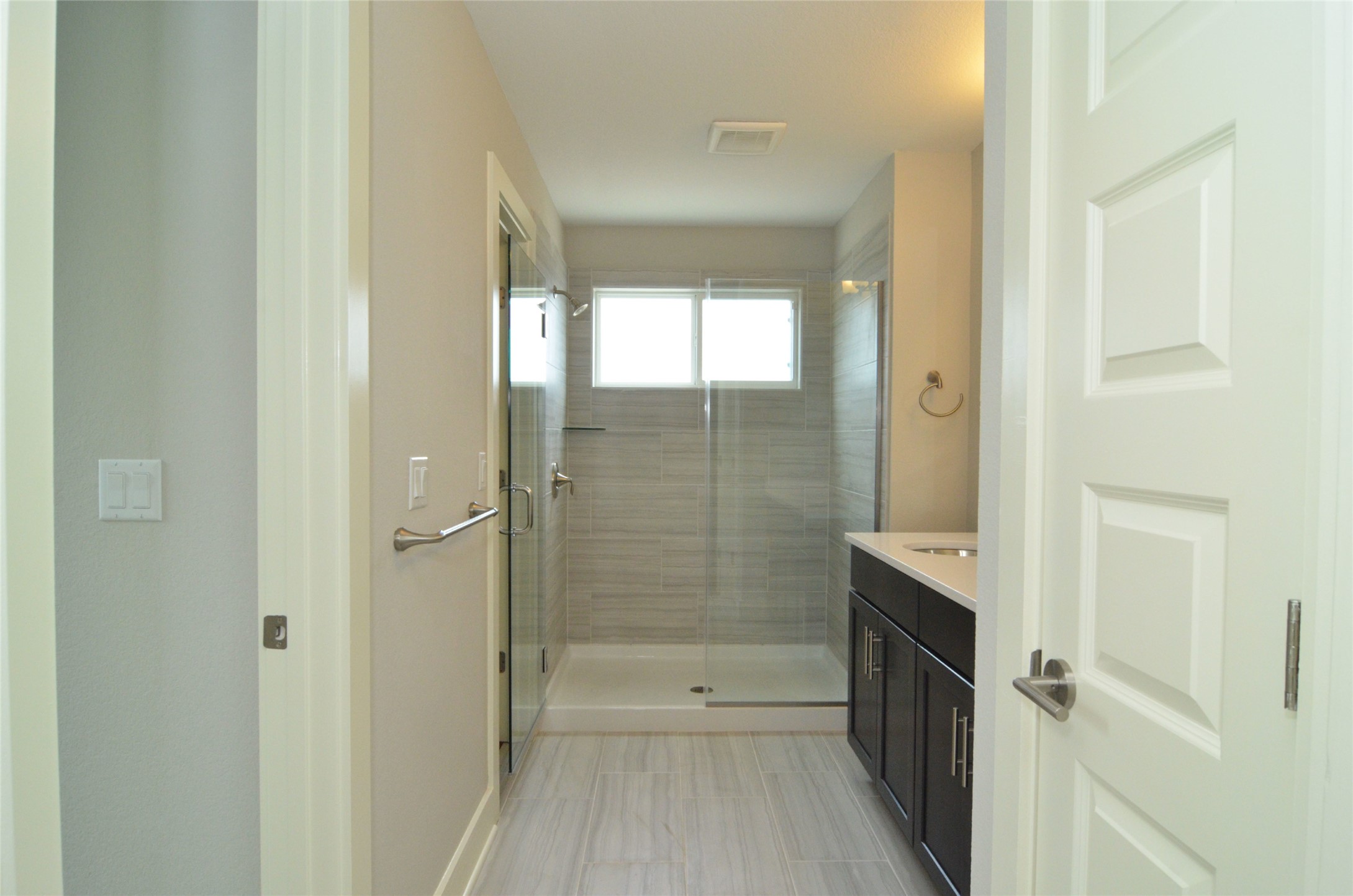 1916 Cleese Drive Austin, TX 78741 - Photo 24 of 36 A well-appointed primary bath features a spacious walk-in shower with tile surround and an elegant single vanity.