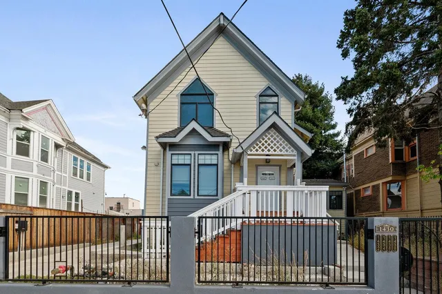 a view of a brick house with large windows and a small yard