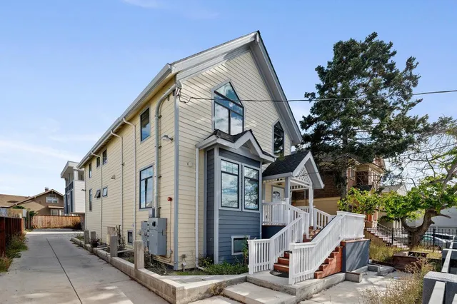 a front view of a house with a tree