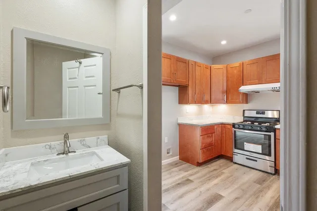 a kitchen with granite countertop a sink stove and refrigerator