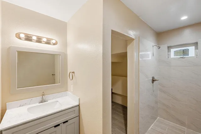 a bathroom with a sink a mirror and a shower