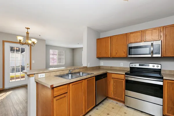 a kitchen with stainless steel appliances granite countertop a sink stove and microwave