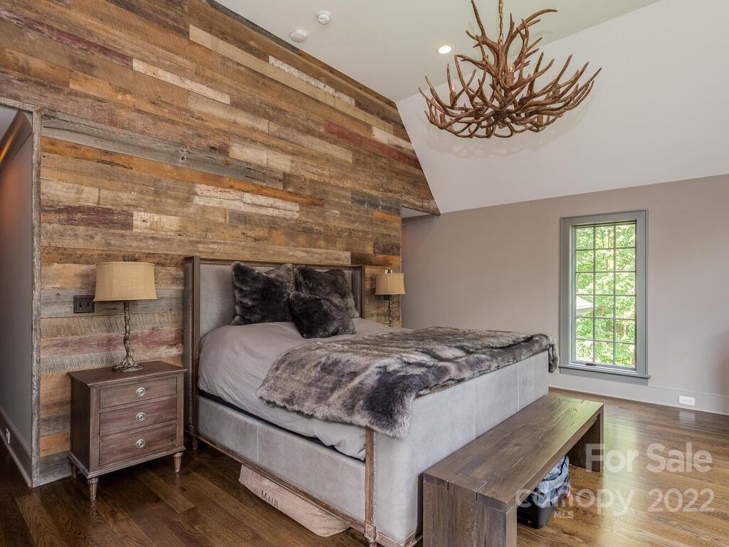 13601 Girl Scout Road Charlotte, NC 28278 - Photo 25 of 45 a bedroom with a bed and a chandelier