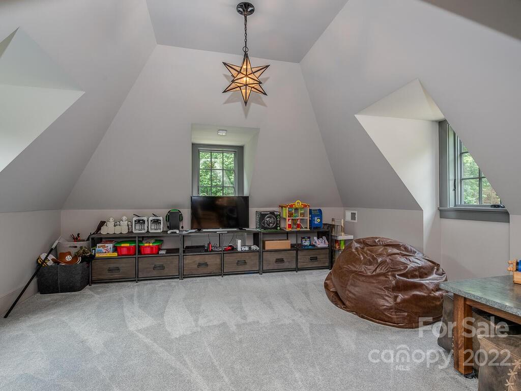 13601 Girl Scout Road Charlotte, NC 28278 - Photo 29 of 45 a bedroom with bed and a chandelier