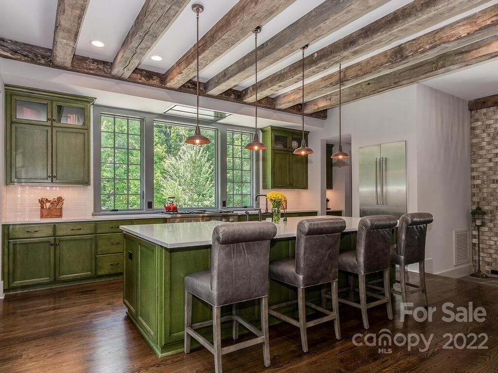 13601 Girl Scout Road Charlotte, NC 28278 - Photo 6 of 45 a dining hall with stainless steel appliances granite countertop a stove a sink dishwasher and chairs with wooden floor