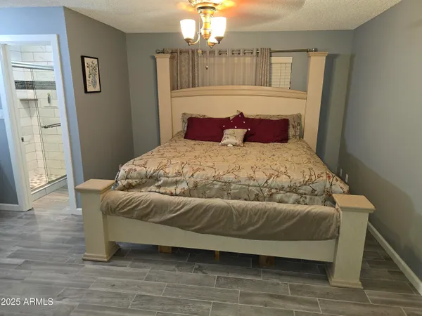 a bedroom with a bed and a chandelier