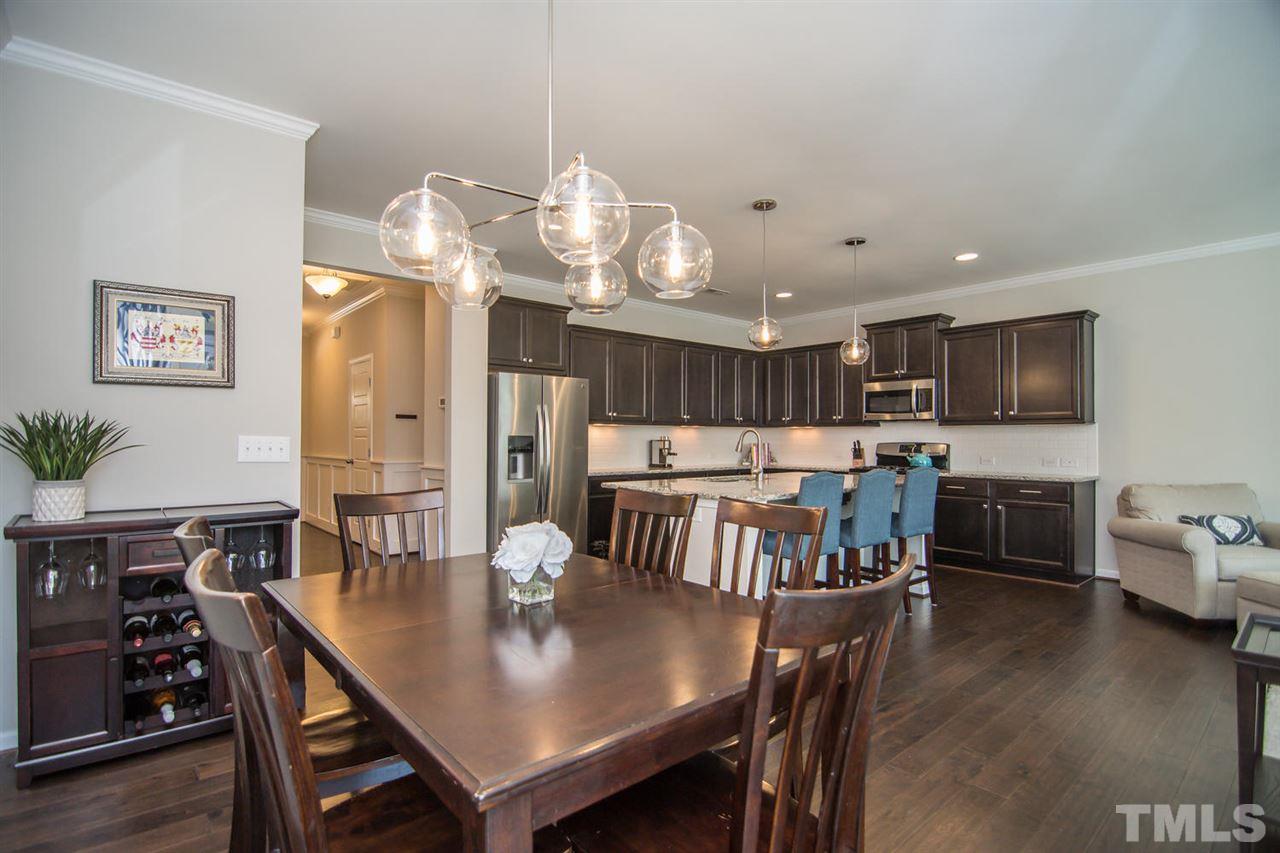 1240 Exchange Place Durham, NC 27713 - Photo 9 of 30 a view of a dining room with furniture a chandelier and wooden floor