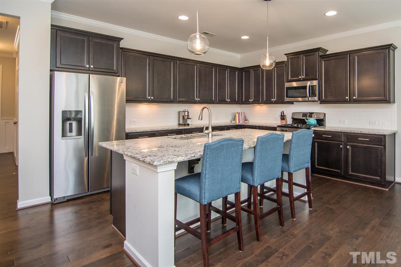 1240 Exchange Place Durham, NC 27713 - Photo 10 of 30 a kitchen with granite countertop stainless steel appliances a sink a stove a refrigerator cabinets and wooden floor