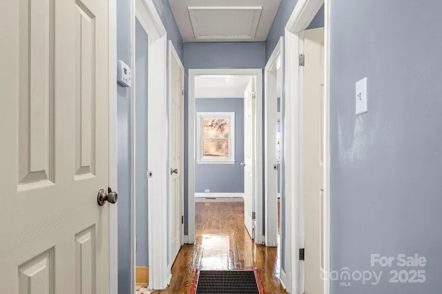 a view of a hallway with wooden floor and closet area