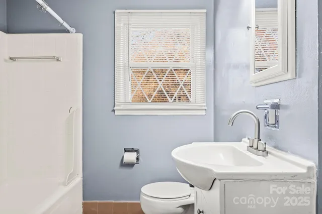 a bathroom with a sink a toilet and a window