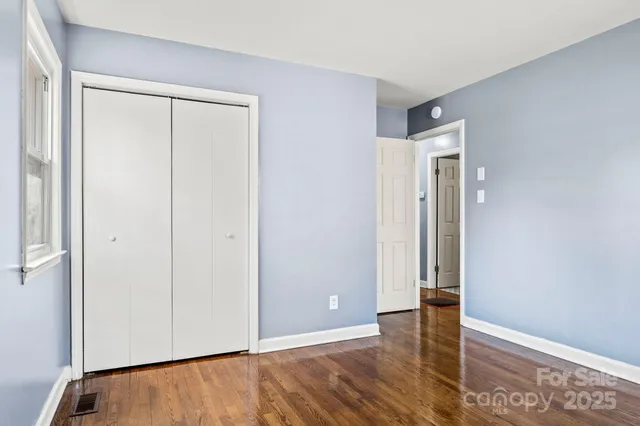 an empty room with wooden floor and a window