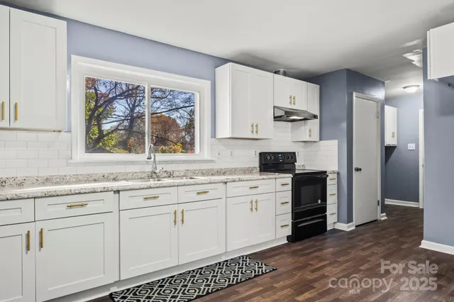 a kitchen with granite countertop white cabinets and white appliances