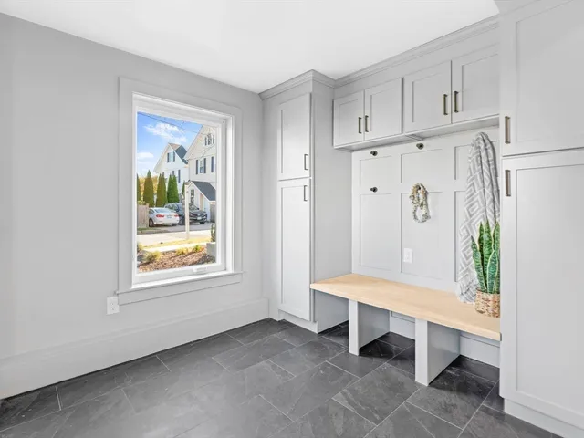 a hallway with white cabinets and wooden floor