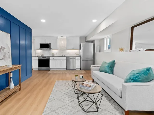 a living room with furniture a flat screen tv and kitchen view