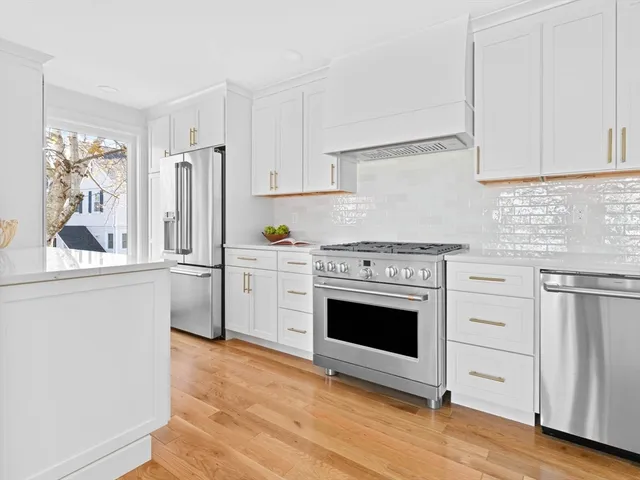 a kitchen with stainless steel appliances a stove a refrigerator and cabinets