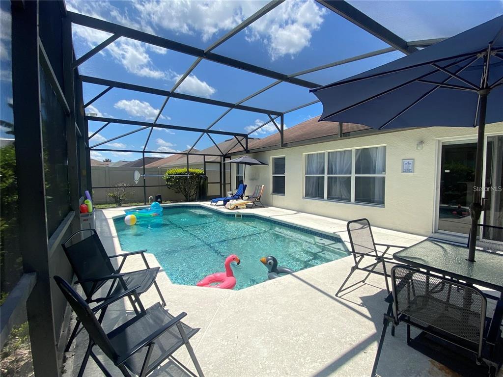 a view of a patio with table and chairs under an umbrella