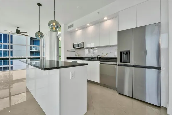 a kitchen with kitchen island a counter top space appliances and cabinets