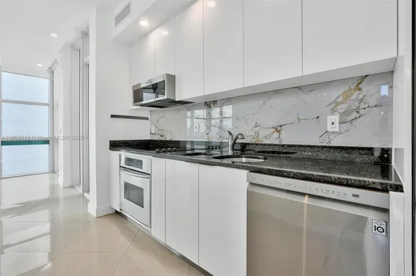 a kitchen with stainless steel appliances granite countertop a stove microwave and refrigerator