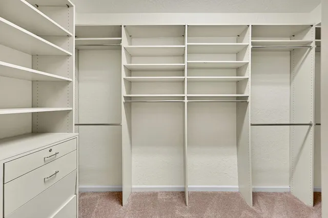 a view of walk in closet with empty racks
