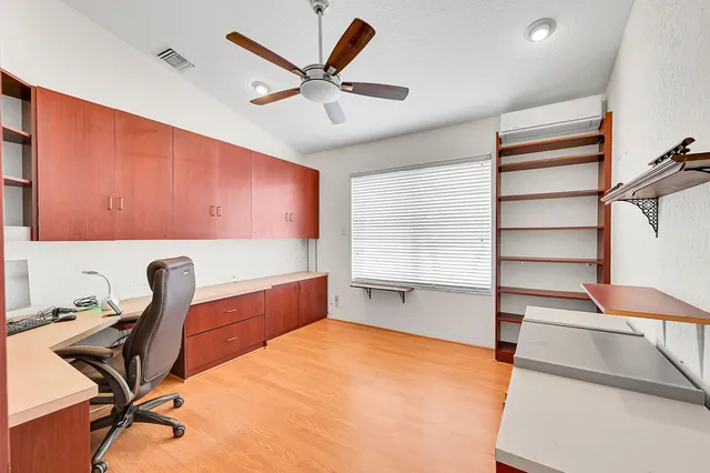 a room with a chair and ceiling fan