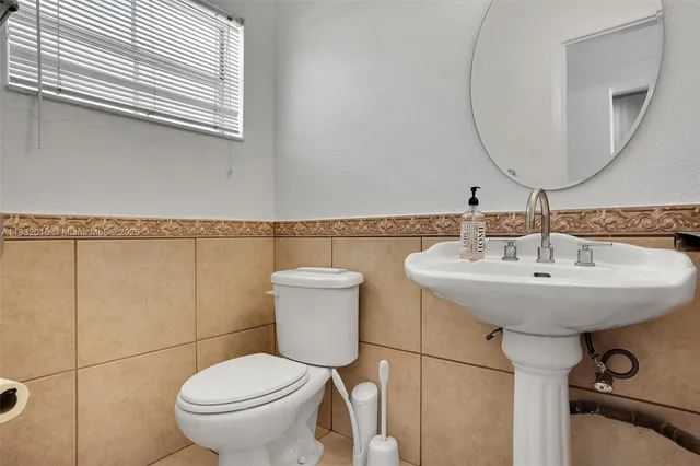 a bathroom with a toilet sink and mirror