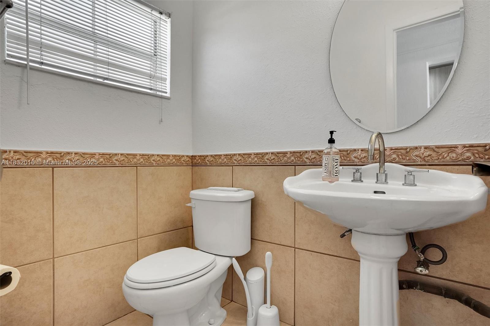 8650 Southwest 67th Avenue, Unit 1025 Pinecrest, FL 33156 - Photo 16 of 26 a bathroom with a toilet sink and mirror